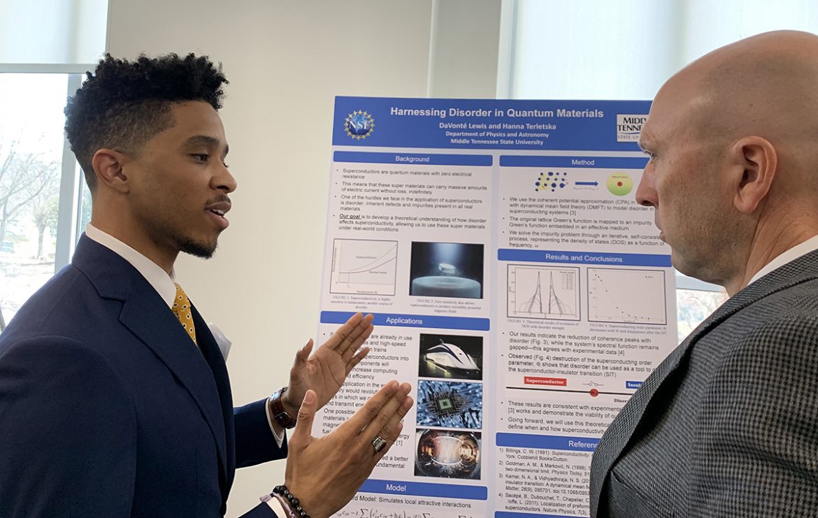 MTSU senior physics major DeVonte Lewis, left, explains his research to Greg Rushton, director of the Tennessee STEM Education Center at MTSU, during the annual Posters at the Capitol event Wednesday, Feb. 16, at the Tennessee State Capitol on Nashville, Tenn. The event features undergraduate student researchers from seven state universities, including MTSU. (MTSU photo Randy Weiler)
