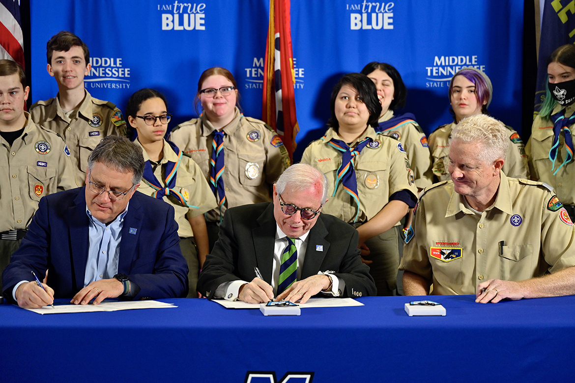 Seated from left, MTSU Provost Mark Byrnes, former Middle Tennessee Council of the Boy Scouts of America President J.B. Baker, a member of the university’s Board of Trustees, and Council Scout Executive and CEO Larry Brown sign the renewal document at the 32nd annual MTSU Merit Badge University as scouts look on Saturday, Feb. 19, on the Middle Tennessee State University campus. (MTSU photo by Cat Curtis Murphy)