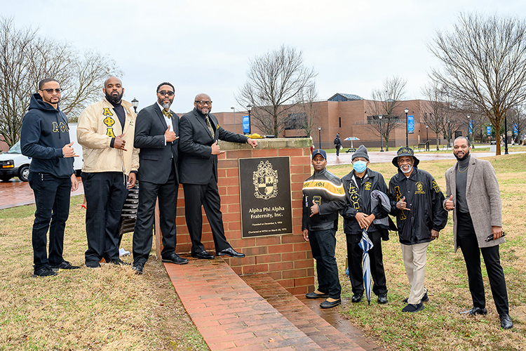 Members of Alpha Phi Alpha Fraternity Inc. pose beside a plaque honoring their organization on the Student Union Commons following a Feb. 17 dedication ceremony inside the Student Union. (MTSU photo by J. Intintoli)