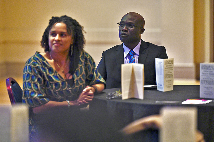 Dr. Andrew Owusu, right, a professor of health and human performance, listens to testimonials praising his record of teaching, service and research at the 2022 John Pleas Faculty Award ceremony Feb. 23 in the James Union Building at MTSU. At left is his wife, Dr. Danielle Brown, a lecturer in the Department of Biology. (MTSU photo by Cat Curtis Murphy)