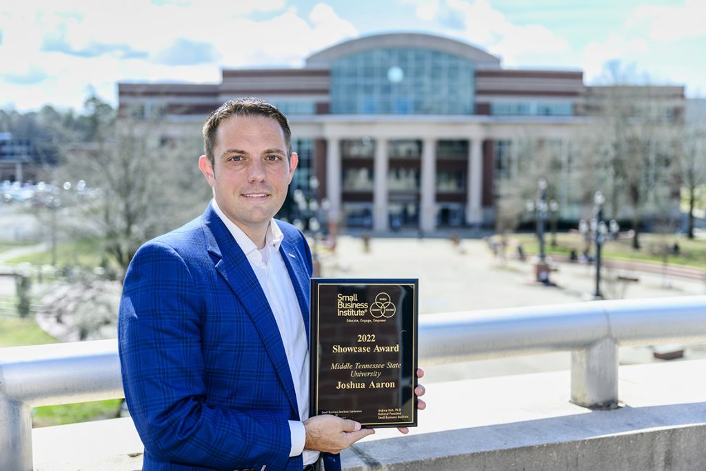 MTSU management professor Joshua Aaron, Pam Wright Chair of Entrepreneurship in the Jennings A. Jones College of Business, holds the Small Business Institute’s 2022 “Showcase Award” on the balcony of the Business and Aerospace Building. Aaron accepted the award, signifying the top entrepreneurship program of the year within the professional development organization, at the annual SBI national conference in Charleston, South Carolina, in late February. (MTSU photo by J. Intintoli)