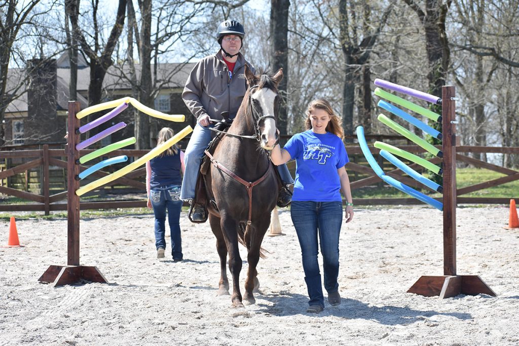 Led by an MTSU horse science student mentor, a participant the Center of Equine Recovery for Veterans rides a horse named Floyd during a therapy session. The annual MTSU CERV Spring Spectacular Horse Show will be held starting at 8 a.m. Saturday, April 1, in the main arena of the Tennessee Livestock Center, 1720 Greenland Drive, and benefits the veterans therapy program. (MTSU file  photo by Ashley Gallagher)