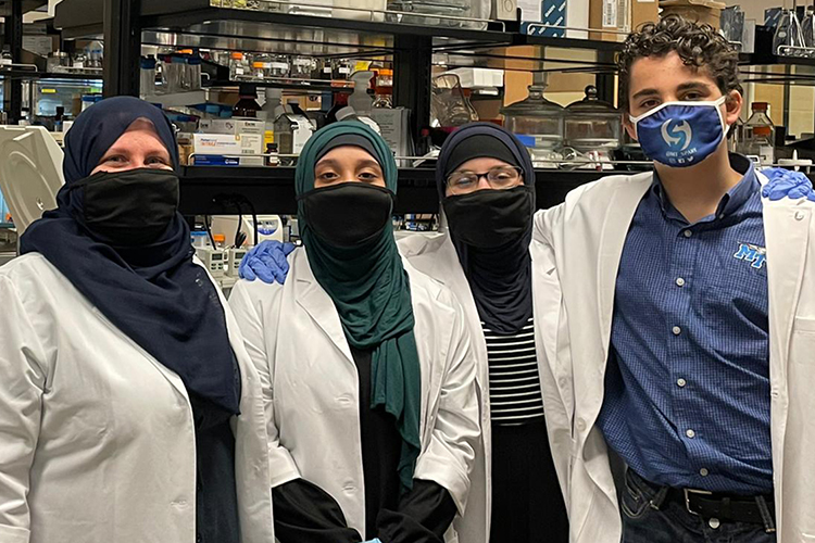 Khadijah Alnassari, left, poses proudly with her children, Zaynab, Fatimah, and Ahmed in an MTSU science lab. All four Alnassaris are MTSU students and organizers of the Festival of Veils, which is scheduled for March 19 on the Student Union Commons. (Photo submitted)