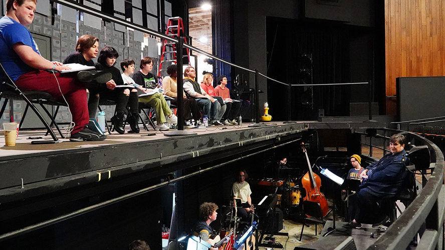 Cast members for the April 7-10 MTSU Theatre production of "Fun Home" pause during rehearsals with musical director Angela Tipps, seated at far right, and members of the student orchestra from the School of Music. Cast members seated on stage in Tucker Theatre are, from left, MTSU students Christopher Cooper, Isaac Sisunik, Emma Bastin, Julia Degnan, Llewyn Beaver, Stokely Ellison, Payton McCarthy, Carmen Dennison and Logan Purcell. Information on tickets, a digital program listing the cast and crew, and more show details are available at https://mtsu.edu/theatreanddance/funhome.php.(MTSU Theatre photo)