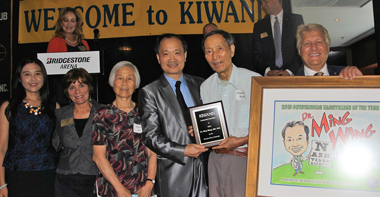 Dr. Ming Wang, center left holding award, accepts the Kiwanis Club of Nashville's 2015 Outstanding Nashvillian of the Year during a July 2016 at the Bridgestone Arena in Nashville, Tenn. (Photo courtesy of drmingwang.com)