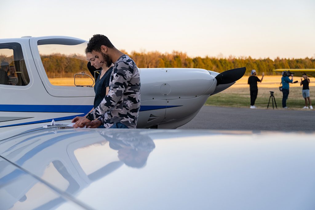 Two MTSU aerospace students use the wing of one of the university's Diamond aircraft flight training planes on the tarmac to create paper airplanes to compete in the Red Bull Paper Wings local qualifying event Thursday, March 3, at the MTSU Flight Operations Center. More than 100 students competed. (MTSU photo by Cat Curtis Murphy)