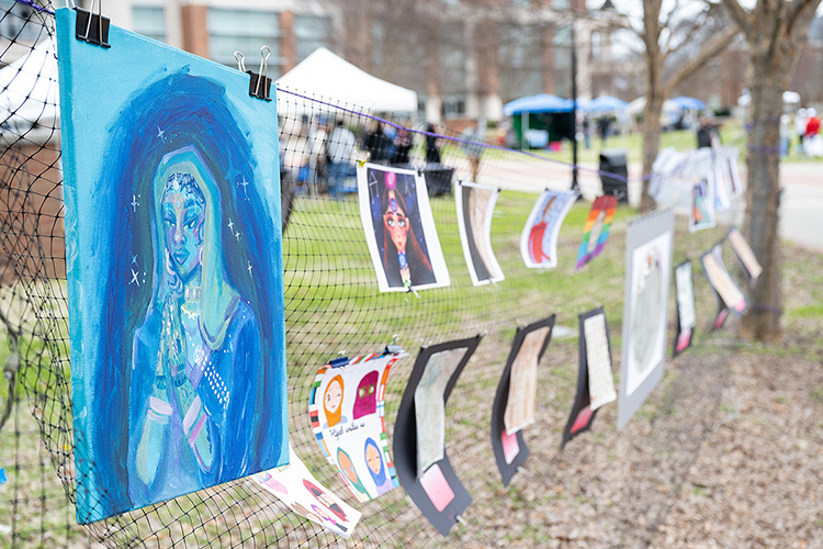 Entries in an art contest line a mesh partition on the Student Union Commons at the Festival of Veils, a March 19 event celebrating the ways women of various religions use veils. (MTSU photo by Cat Curtis Murphy)