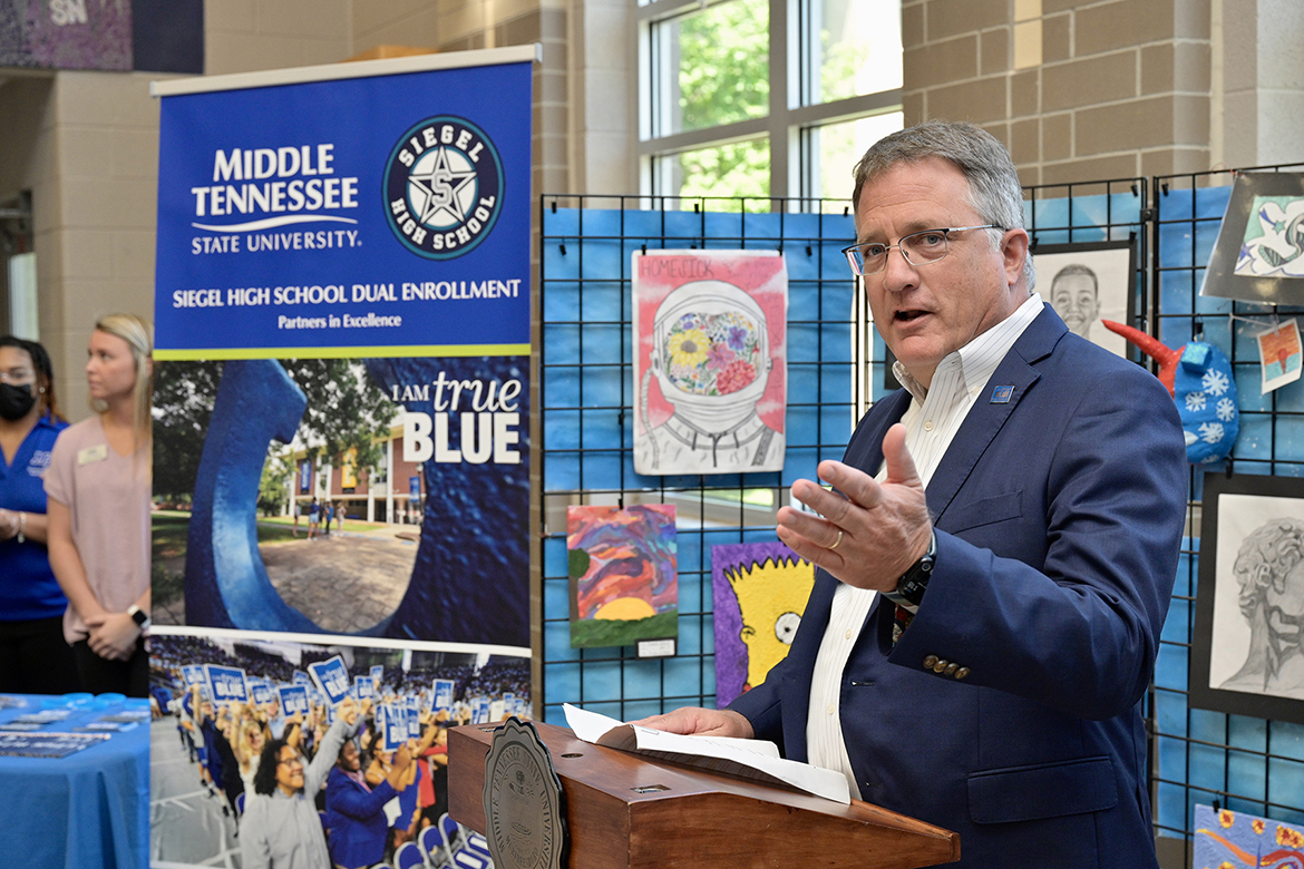 Standing before a display of student art work, MTSU Provost Mark Byrnes touts the success of the Siegel Humanities Academy, a collaboration between MTSU and Siegel High School, during an April 26 ceremony at Siegel. (MTSU Photo by Andy Heidt)