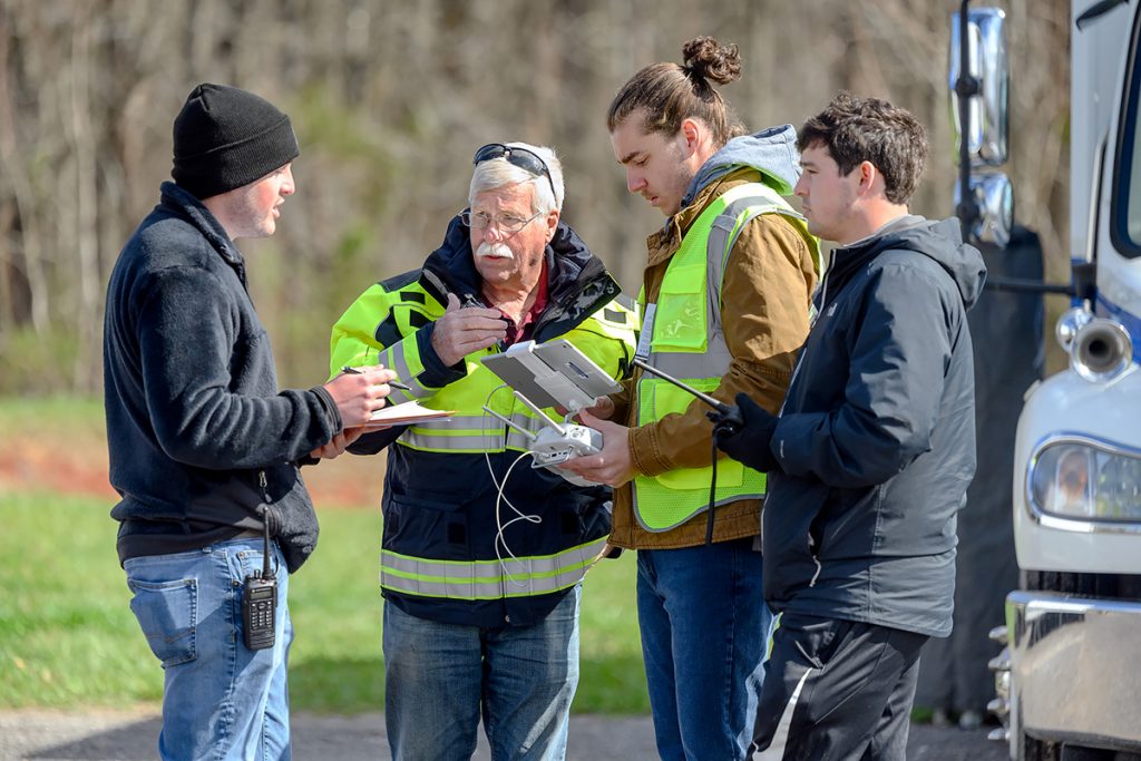 Zackary Whittle, left, of Lafayette, Ga., shares data with assistant professor Kevin Corns and fellow aerospace unmanned aircraft systems classmates Michael Clancy of Franklin, Tenn., and Aiden Galdino of Brentwood, Tenn., during the April 1 mapping mission at Cummins Falls State Park near Cookeville, Tenn. Corns is director of the UAS program. (MTSU photo by J. Intintoli)