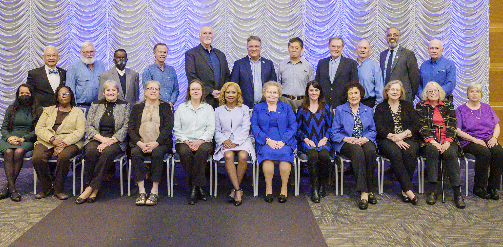 MTSU Provost Mark Byrnes, standing at the center of the back row, joins 22 of the university’s 75 employees retiring in the 2021-22 academic year for a photo at the university’s annual Retired Employee Reception April 6 in the Student Union Ballroom. The 75 retiring employees honored this year have a combined 1,959 years of service to the university. (MTSU photo by Andy Heidt)