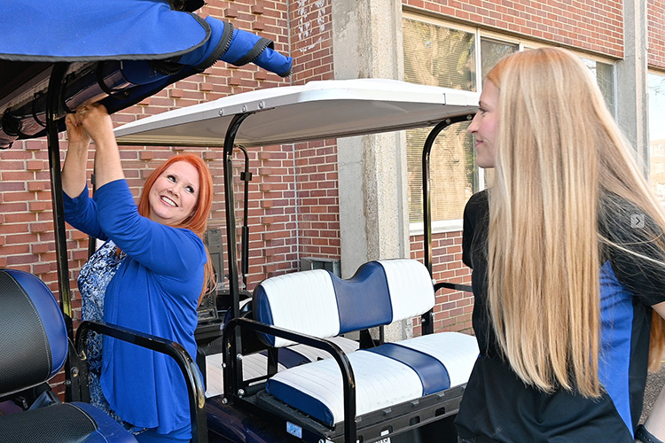 Lauren Alligood, Middle Tennessee State University graduate student and assistant, right, and Sherry Fuller, MTSU College of Graduate Studies office coordinator, prepare a golf cart for one of the College of Graduate Studies new golf cart campus tours for prospective students on March 17, 2022, near Walnut Grove on campus. (MTSU photo by Stephanie Barrette)