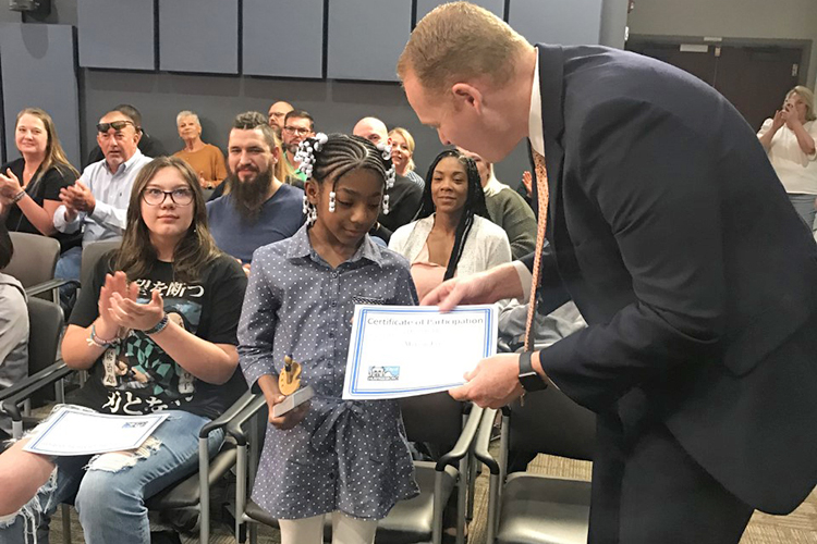 Murfreesboro City Schools Director Trey Duke, right, presents Hobgood Elementary School student Morgan Lee with the Best of Show trophy and certificate for her artwork entered in the 2021-22 Murfreesboro Student Art Show. (Photo courtesy of Murfreesboro City Schools)