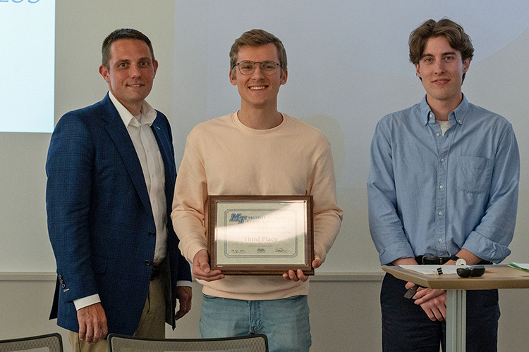 MTSU graduating senior Pavel Sazonov, center, and graduate student Conner McAnally, right, are presented the third-place plaque and $4,000 prize by Joshua Aaron, management professor and holder of the Wright Chair of Entrepreneurship, at the conclusion of the 2022 Business Plan Competition Finals held April 27 in the Academic Classroom Building. The event is presented by the Pam Wright Chair of Entrepreneurship within the Department of Management. The students won third place for their proposal for MapSchool, a web mapping platform for educational institutions that allows students to explore campuses. (MTSU photo by Darby Campbell-Firkus)