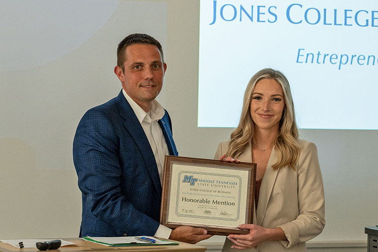 MTSU rising senior Hannah Beyler, right, is presented an honorable mention plaque and $2,000 prize by Joshua Aaron, management professor and holder of the Wright Chair of Entrepreneurship, at the conclusion of the 2022 Business Plan Competition Finals held April 27 in the Academic Classroom Building. The event is presented by the Pam Wright Chair of Entrepreneurship within the Department of Management. Beyler was recognized for The Us Agency, the nonprofit media consulting agency she founded that helps nonprofit organizations through a suite of services. (MTSU photo by Darby Campbell-Firkus)
