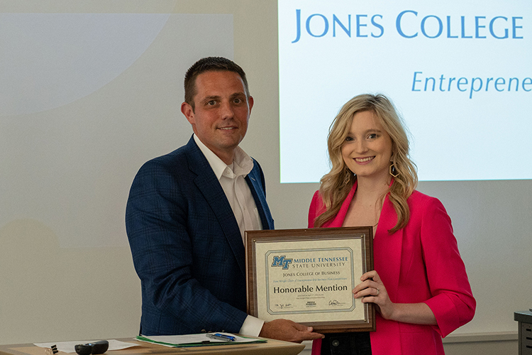MTSU student Alexandria Leverette is presented an honorable mention plaque and $2,000 prize by Joshua Aaron, management professor and holder of the Wright Chair of Entrepreneurship, at the conclusion of the 2022 Business Plan Competition Finals held April 27 in the Academic Classroom Building. The event is presented by the Pam Wright Chair of Entrepreneurship within the Department of Management. Leverette was recognized for The Social Consultant, a business that offers social media management and coaching to business owners. (MTSU photo by Darby Campbell-Firkus)