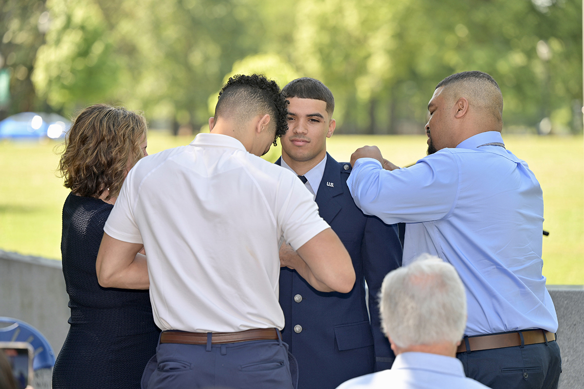 The family of recent MTSU graduate Jalen Ervin, second from right, of Chattanooga, Tenn., pins second lieutenant bars on his uniform Saturday, May 14, during the Air Force ROTC Detachment (TSU) commissioning ceremony at the MTSU Veterans Memorial outside the Tom H. Jackson Building. His family includes mother Lisa Ervin, brother Michael Ervin and father Starling Ervin. Michael Ervin, also a recent MTSU grad, expects to earn his commissioning in August. (MTSU photo by Andy Heidt)