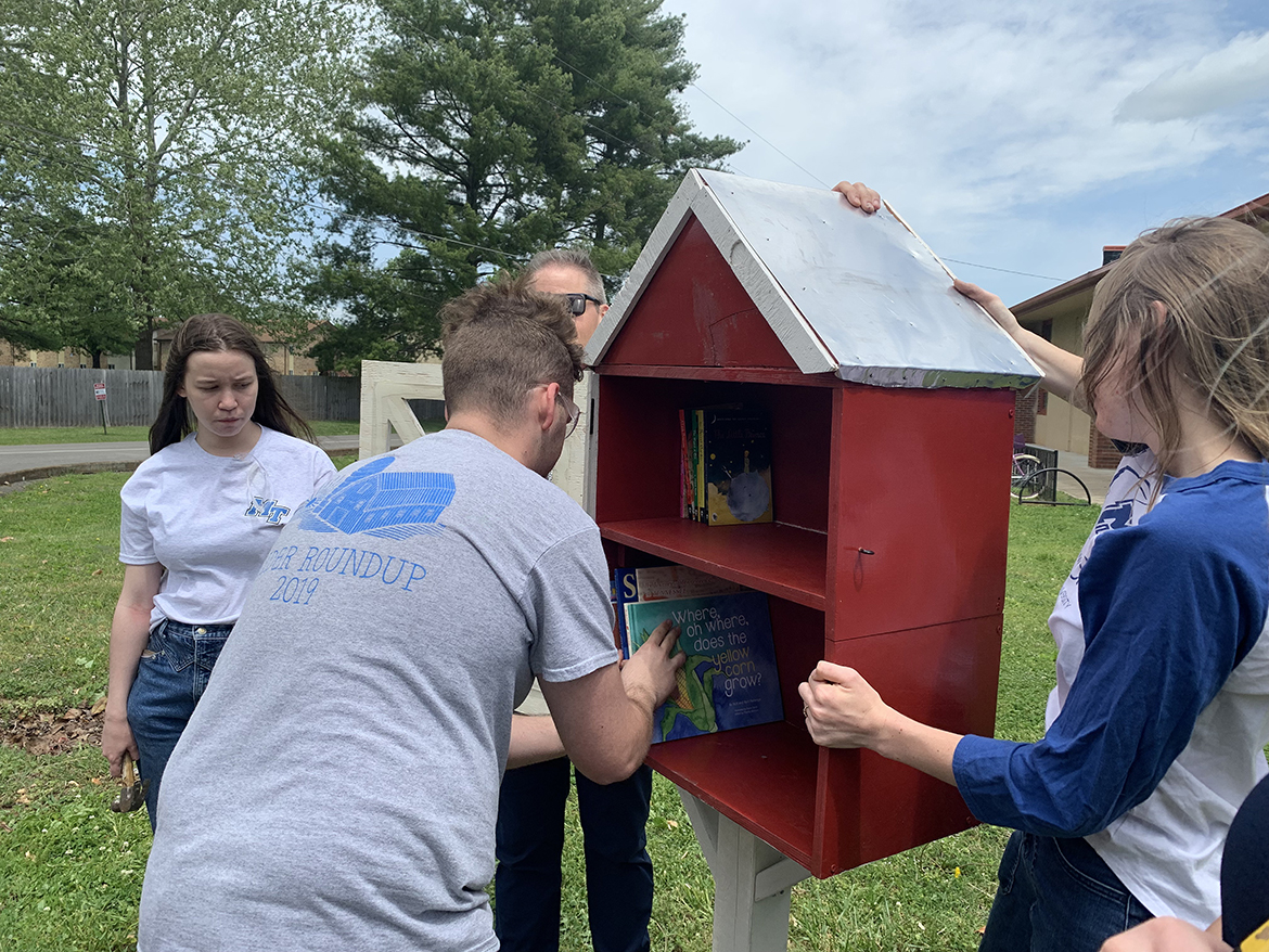 Colby Chapman, second from left, places agriculture-related books for children into the Little Free Library he and four other MTSU agricultural education majors made for Reeves-Rogers Elementary School students. Observing are Angayla Maxwell, left, assistant professor Chaney Mosley and Lily Steed. (MTSU photo by Randy Weiler)