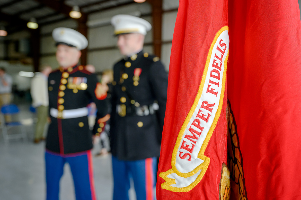 Standing near the U.S. Marine Corps flag, Marine Sgt. Jason Pickard, left, and new 2nd Lt. Isaac Wehner await the commissioning ceremony for Wehner May 20 in the Donald McDonald Hangar at MTSU’s Flight Operations Center at Murfreesboro Airport. Both are graduates of the MTSU aerospace program in the professional pilot concentration. (MTSU photo by J. Intintoli)