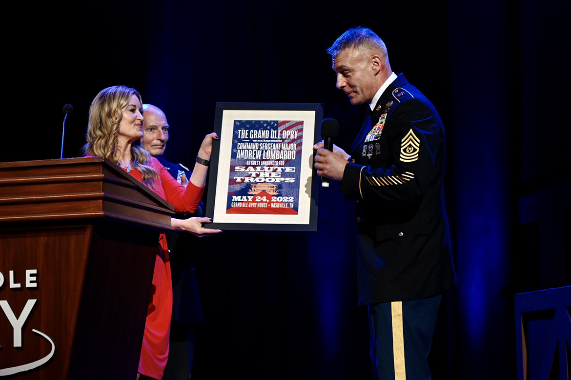 Grand Ole Opry announcer Kelly Sutton, left, presents a plaque to Army Reserve Command Sgt. Maj. Andrew Lombardo during the annual Salute to Troops Opry show at the Grand Ole Opry House in Nashville, Tenn. Lombardo, his immediate staff and MTSU officials including President Sidney A. McPhee attended the performance that included country music singer, Army veteran and former MTSU student Craig Morgan wrapping up the show. (MTSU photo by James Cessna)