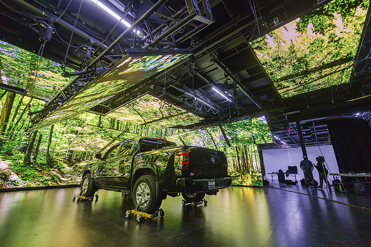 A forest scene displayed on multiple LED screens in a Nashville studio is reflected on a truck used by MTSU media students during production for a "teaser" commercial in Nashville for the Department of Media Arts' new extended reality, or XR, stage, a new type of film and video production stage that will enable them to create projects anywhere, anytime. The MTSU XR facility, the only one of its kind at a Tennessee university, will be ready for classes this fall. (MTSU photo by Andy Heidt)