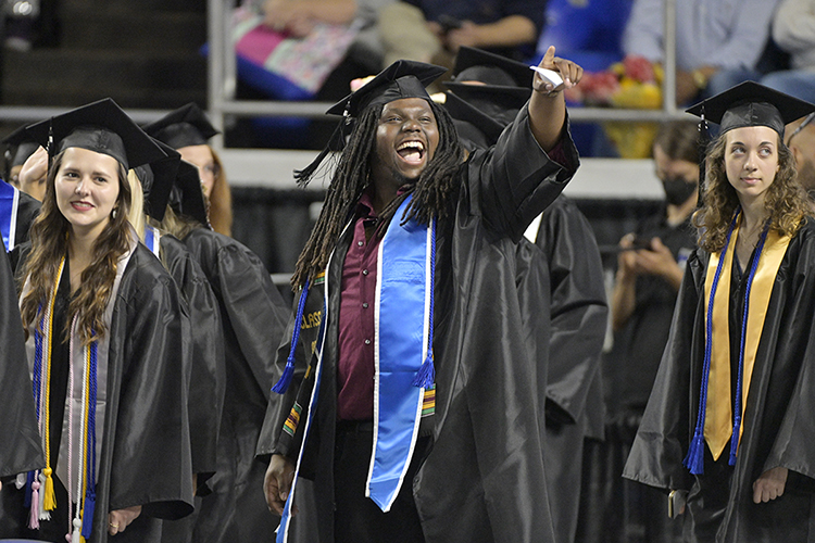 Three Middle Tennessee State University prospective graduates wait to walk across the stage and accept their new degrees in Hale/Earle Arena inside Murphy Center Saturday, May 7, during the university's spring 2022 afternoon commencement ceremony. MTSU awarded 2,474 degrees — 2,041 to undergraduates and 433 to graduate students — during its three-ceremony spring 2022 commencement event. (MTSU photo by Andy Heidt)