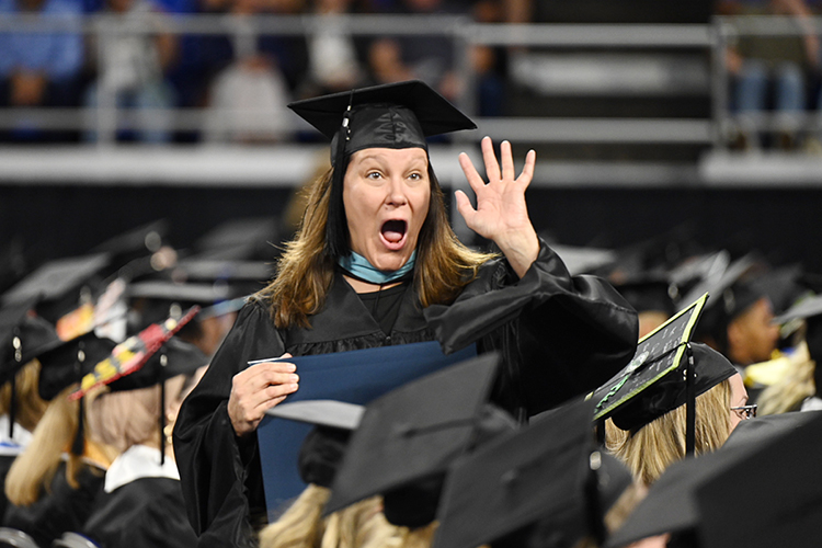 An excited Middle Tennessee State University graduate holds her new diploma and waves to supporters Saturday, May 7, during the university's spring 2022 morning commencement ceremony in Hale/Earle Arena inside Murphy Center. MTSU awarded 2,474 degrees — 2,041 to undergraduates and 433 to graduate students — during its three-ceremony spring 2022 commencement event. (MTSU photo by James Cessna)