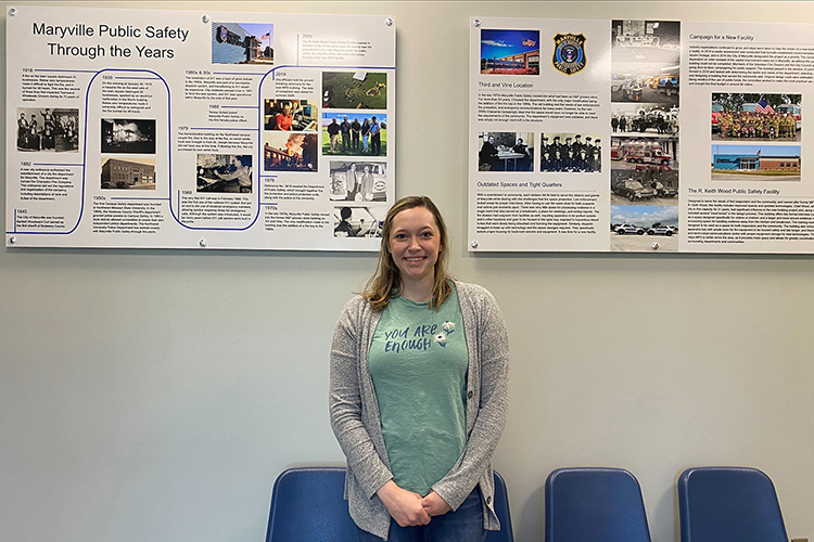 MTSU student Emily Tillman Hougland stands proudly in front of the permanent historical exhibit she created for the R. Keith Wood Public Safety Facility in Maryville, Mo.