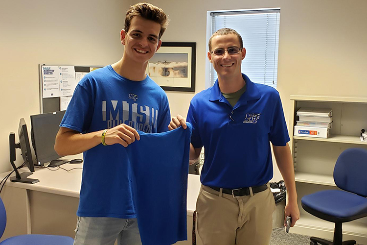 Travis Houser, recent graduate of Middle Tennessee State University’s Aeronautical Science master’s program, right, holds the shirt tail of MTSU aviation student Riley Marshall, the first student he taught as a flight instructor, to commemorate Marshall piloting his first solo flight, an old school pilot tradition, in December 2019 on campus. (Photo courtesy of Travis Houser)