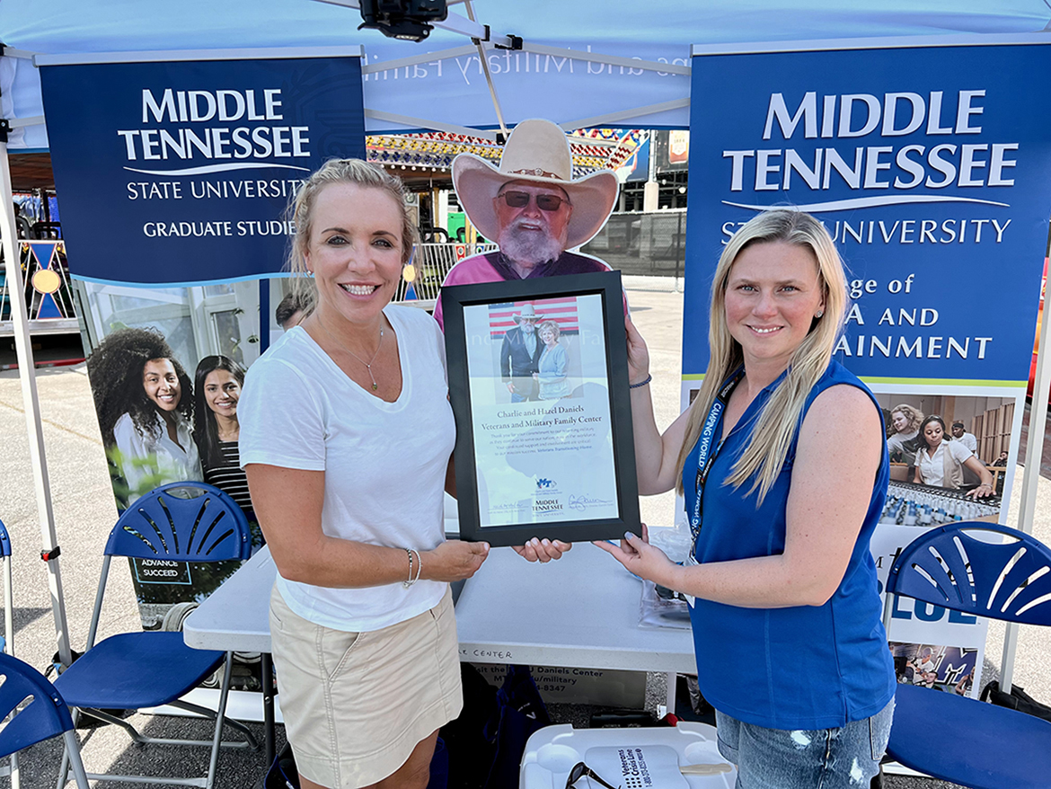 Michelle Boykin, right, Rackley Roofing’s chief operating officer and an alumna of MTSU, is honored Friday, June 24, at the Nashville Superspeedway by MTSU Daniels Center Director Hilary Miller with a commemorative plaque for her company’s support of veterans. They were attending the Rackley Roofing 200 NASCAR Camping World Truck Series event at the Nashville Superspeedway in Gladeville, Tenn. (MTSU photo by Andrew Oppmann)