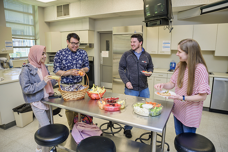 In this April 2022 file photo, students in MTSU professor Janet Colson's nutrition and food science class prepare healthy food in a kitchen in the Ellington Human Sciences Building. Pictured, from left, are Nada Abdelghani, Brian Segovia, Tylor Armistead, and Alicia Burns. Burns created PowerPoint slides for "Introduction to Nutrition and Wellness," an open-access textbook for MTSU's "Principles of Nutrition" class and the "Nutrition Across the Lifespan" high school classes.