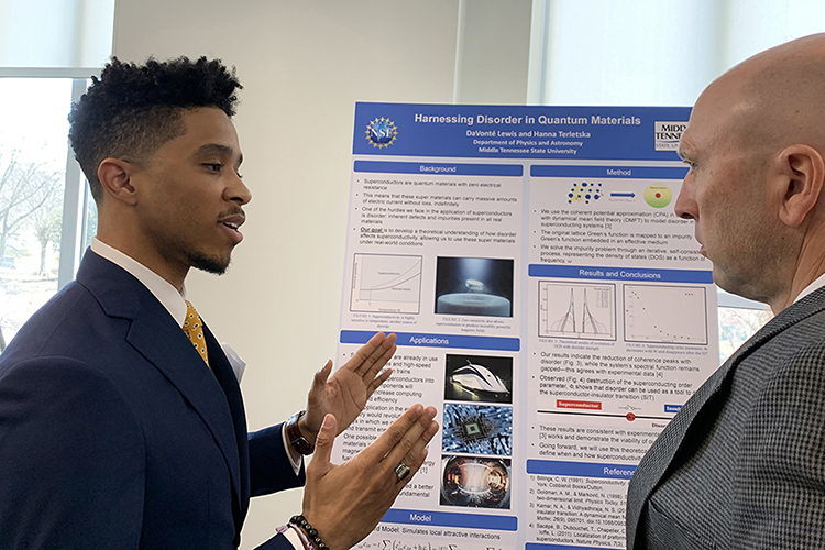 DeVonte Lewis, left, Middle Tennessee State University senior physics major and undergraduate researcher, explains his research to Greg Rushton, director of the Tennessee STEM Education Center at MTSU, during the annual Posters at the Capitol event Feb. 16, at the Tennessee State Capitol in Nashville, Tenn. (MTSU photo Randy Weiler)