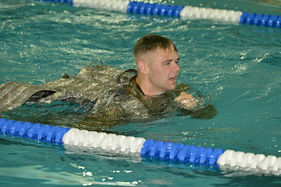 Cole Lukens of Murfreesboro shows the competitors how to accomplish their mission in the swim survival portion of the 2022 All Guard National Best Warrior competition in the Campus Recreation Center indoor pool. A senior business finance major, Lukens won the 2021 national competition and Army National Guard Soldier of the Year distinction. (MTSU photo by Andy Heidt)