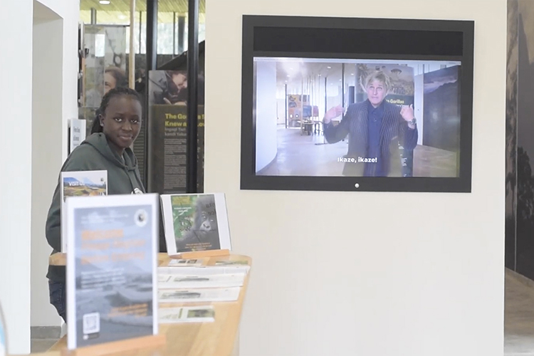 In this screen capture from a virtual tour video, Kadiara King’ai, left, conservation gallery manager at the Ellen DeGeneres Campus of the Dian Fossey Gorilla Fund in Rwanda, introduces a welcome video featuring the comedian who donated seed money that led to the facility’s construction. (Courtesy of YouTube)