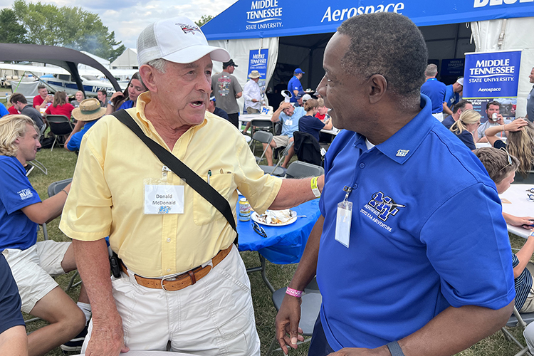 MTSU President Sidney A. McPhee, right, chats with alumnus and longtime Aerospace Department support Donald McDonald on Wednesday, July 27, during a barbeque reception outside MTSU’s large tent at the 2022 EAA AirVenture in Oshkosh, Wis. (MTSU photo by Andrew Oppmann)