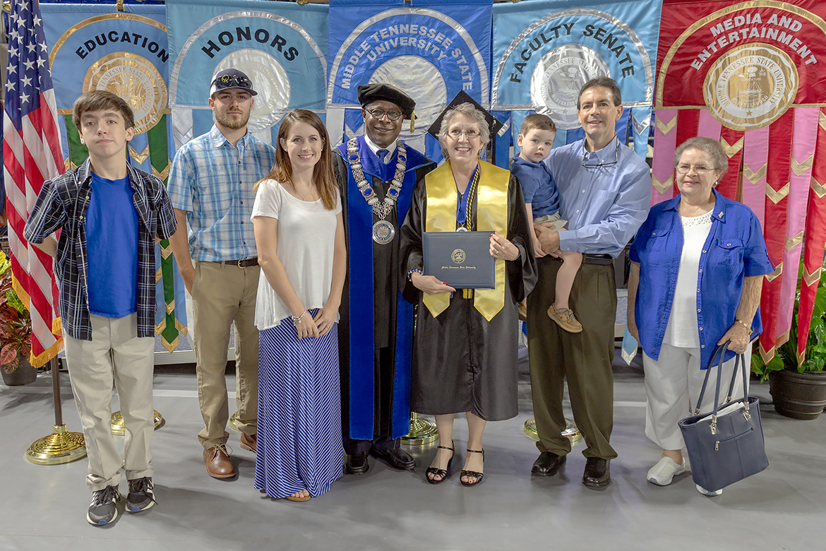 With MTSU President Sidney A. McPhee, fourth from left, Sherry Preston, legal assistant for the Office of the University Counsel, graduated in August 2017 with a Liberal Studies degree and plans to pursue a Master of Professional Studies degree. Full-time MTSU employees can take one course per semester and up to four courses per year free using their fee waiver. A special information session will be held Thursday, July 28, in the Student Union Atrium to help employees discover their opportunities — and not leave money on the table. Also pictured are her son, Blake Preston, far left, now an MTSU student; son-in-law Austin Parker; daughter Jenna Parker; grandson Brantley Flowers; husband, Jimmy Preston; and mother-in-law Betty Preston, a former MTSU student. (MTSU file photo by Eric Sutton)