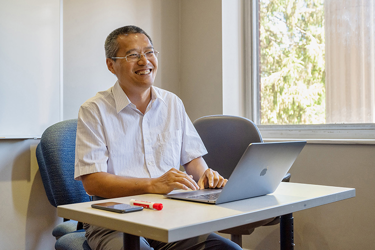 Middle Tennessee State University professor Qiang Wu, director of the university’s new Data Science master’s program, smiles while working with student participants during the Data Dive event held June 18, 2022, inside Kirksey Old Main. (MTSU photo by James Cessna)