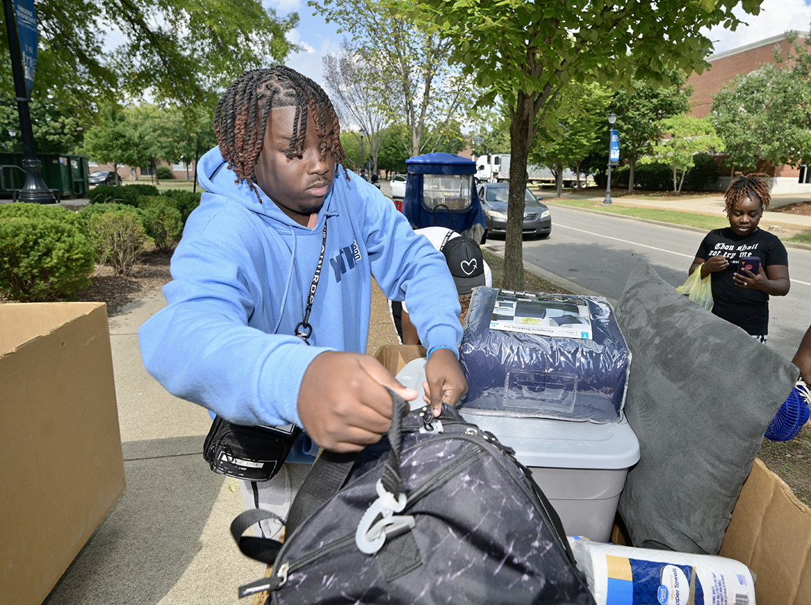 MTSU freshman Daniel Triggs Jr., left, of Memphis, Tenn., loads a bag onto a cart that will be taken to his dorm room in Corlew Hall Friday, Aug. 19, during a move-in day on campus. His mother, Antionette Triggs, stands in the background and other family members and his roommate assisted with the move. Fall classes will begin Monday, Aug. 22. (MTSU photo by Andy Heidt)