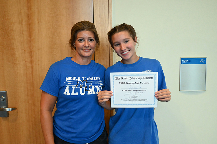 Prospective Middle Tennessee State University student Taylor Letart, right, holds up the certificate for a $22,000 scholarship after her name was drawn during the kickoff event for the university’s True Blue Tour at the Student Union Building Wednesday, Aug. 17, 2022. At left is April Letart, her mother and current MTSU graduate student. (MTSU photo by Stephanie Barrette)