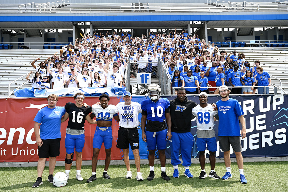 About 300 students from the Office of Student Success’s Scholars Academy and STAR early arrival programs helped unfurl the Blue Zoo banner for the first time this academic year in the student section inside Floyd Stadium Wednesday, Aug. 17. The banner will be unfurled each time the Blue Raider football team scores at home. Pictured in front of the students, from left, are Blue Zoo Vice President Coby Marlow; quarterback Chase Cunningham; wide receiver Jaylin Lane; head coach Rick Stockstill; defensive tackle Ja'Kerrius Wyatt; defensive end Jordan Ferguson; wide receiver Yusuf Ali; and Blue Zoo President Sawyer Roberts. (MTSU photo by J. Intintoli)