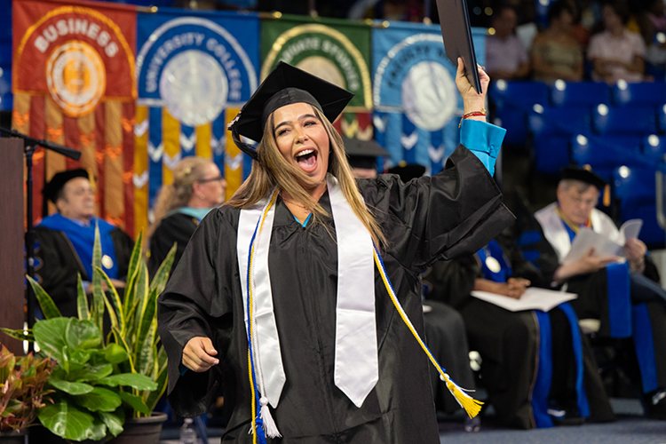 Newly minted University College graduate Laura Esther Espinel raises her hard-earned degree skyward and shouts happily after crossing the stage at Murphy Center Saturday, Aug. 6, at the university's summer commencement ceremony. MTSU presented 857 degrees to undergrad and graduate students during the event, which concludes the university's 111th academic year. (MTSU photo by James Cessna)