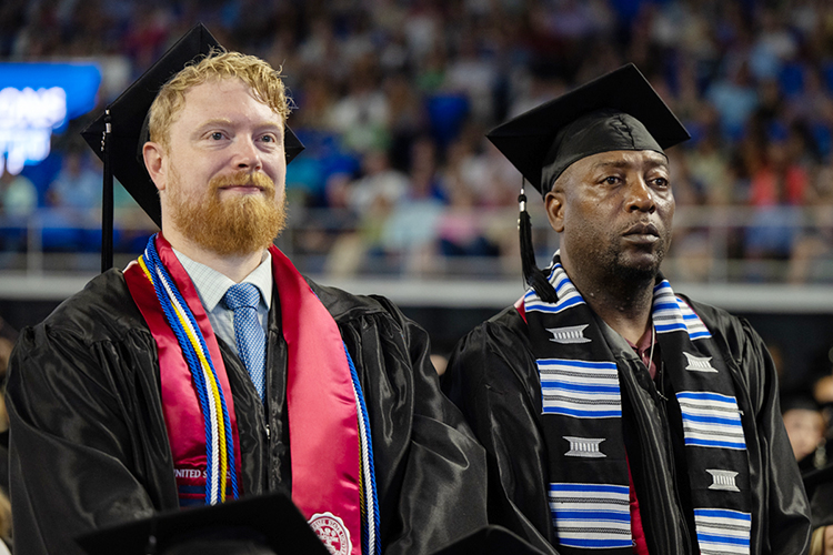 Two MTSU graduates-to-be wait for the August 2022 ceremony to begin in Murphy Center Aug. 6. MTSU presented 857 degrees to undergrad and graduate students during the event, which concluded the university’s 111th academic year. (MTSU file photo by James Cessna)