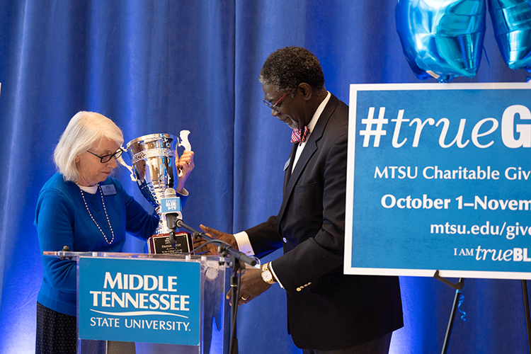 MTSU Associate Provost Mary Hoffschwelle, left, representing the faculty, takes back possession of the Provost Cup from Kim Sokoya, associate dean of the Jennings A. Jones College of Business, which has captured the cup nine straight years for having the highest percentage of participation among the academic colleges during the annual Employee Charitable Giving Campaign, which kicked off Sept. 27 in the Cope Administration Building lobby. (MTSU photo by James Cessna)