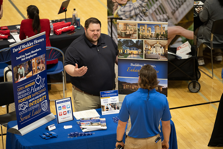 A representative with David Weekley Homes shares the company’s opportunities during the 2022 Fall Career Fair held Sept. 29 in the Campus Recreation Center. (MTSU photo by James Cessna)