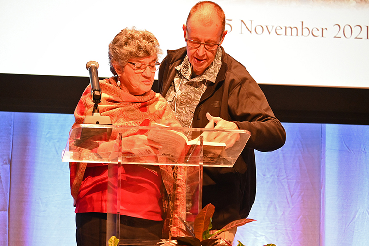 Hanno Weitering, right, a Dutch physics professor at the University of Tennessee, Knoxville, helps child Holocaust survivor Sonja Dubois of Knoxville, Tenn., find a passage to read from her memoir, “Finding Schifrah,” during the university’s 14th biennial Holocaust Studies Conference Sept. 23 in the MTSU Student Union Ballroom. Weitering’s research efforts were critical in helping Dubois complete the book, published a few years ago. (MTSU photo by Jimmy Hart)