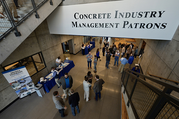 People attending the new Concrete and Construction Management ribbon-cutting ceremony visit in a hallway where signage promotes the Concrete Industry Management Patrons, a group of industry representative who have supported the CIM program for more than 25 years. The event took place Thursday, Oct. 13. (MTSU photo by Andy Heidt)