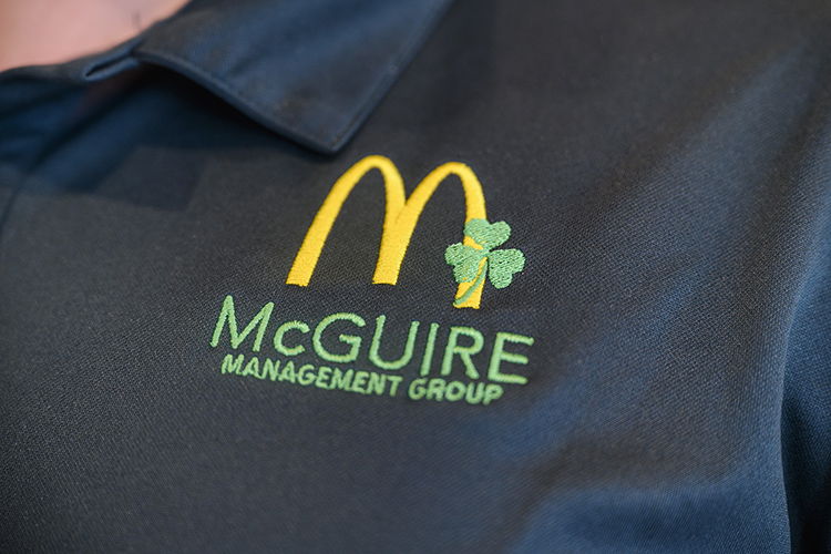 This file photo shows an up-close shot of an employee uniform logo for McGuire Restaurant Group, which operates 20 McDonald’s restaurants, including 10 in Murfreesboro, and others around the region. McGuire and MTSU forged a partnership in 2021 that pays full tuition for qualifying employees returning to school to obtain their degrees. (MTSU file photo)