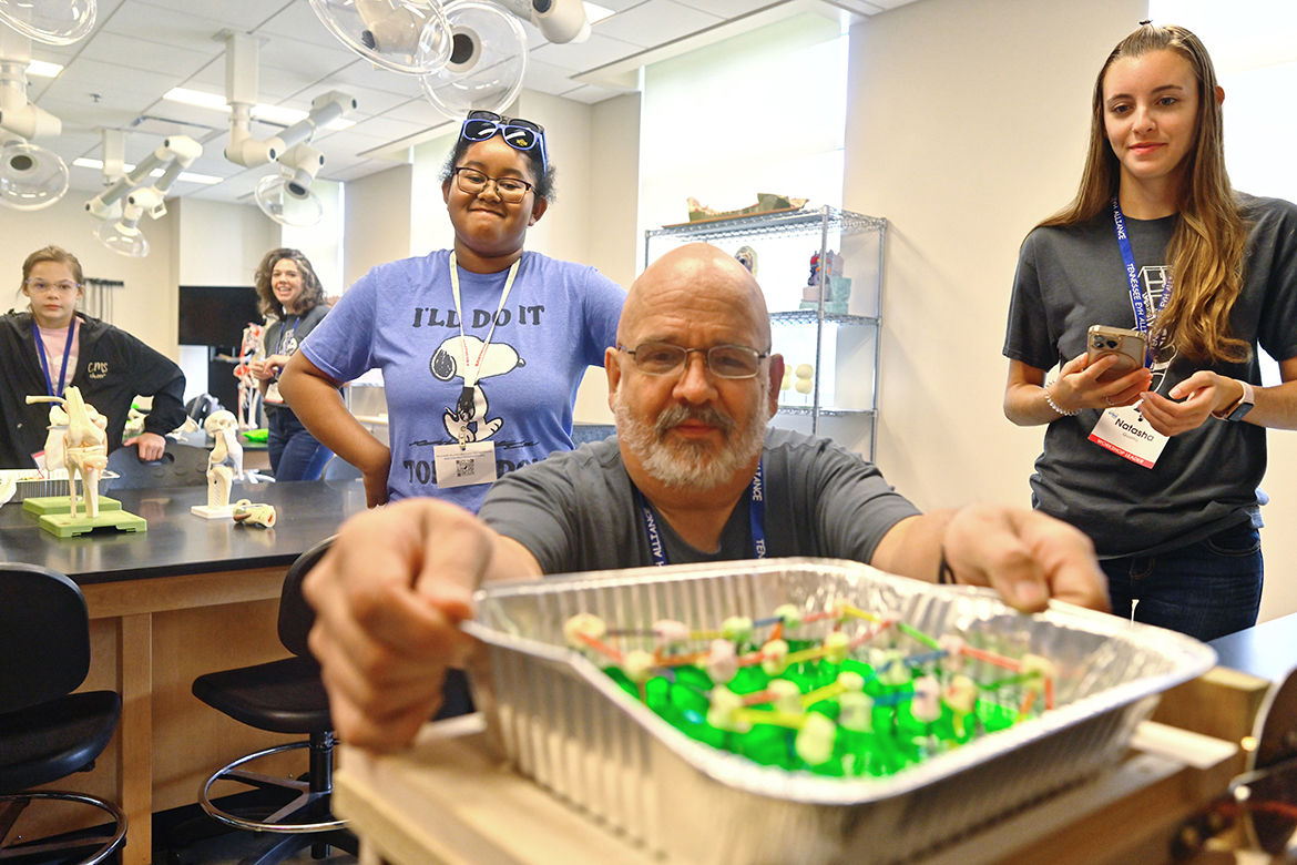 Kurt Hallquist, a mechanical engineer with Schneider Electric in Smyrna, Tenn., conducts a test on a marshmallow and gelatin activity a group of middle school students collaborated on during the 26th annual Tennessee Girls in STEM at MTSU math and science conference Saturday, Sept. 24. Watching to see if it passes are DeAri Gordon, 12, of Murfreesboro, Tenn., who is in the seventh grade at Tennessee National Virtual Academy, and workshop leader Natasha Quattro of Antioch, Tenn., an electrical engineer with Schneider Electric. (MTSU photo by Cat Curtis Murphy)