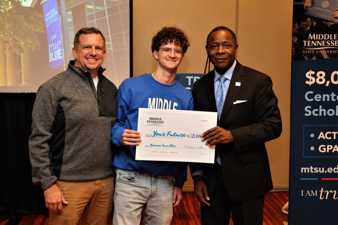 As his father, Dylan Owens, left, shares the moment, Chaz Owens receives a $10,000 scholarship from MTSU President Sidney A. McPhee during the True Blue Tour student reception in Louisville, Ky., Nov. 2, at the Marriott East. They drove 90 minutes to attend the tour event held Nov. 1 in Lexington, Ky., but planned to attend both, in hopes of winning a scholarship. Chaz Owens is an Atherton High School baseball player planning to study music business at MTSU. (MTSU photo by David Foster)
