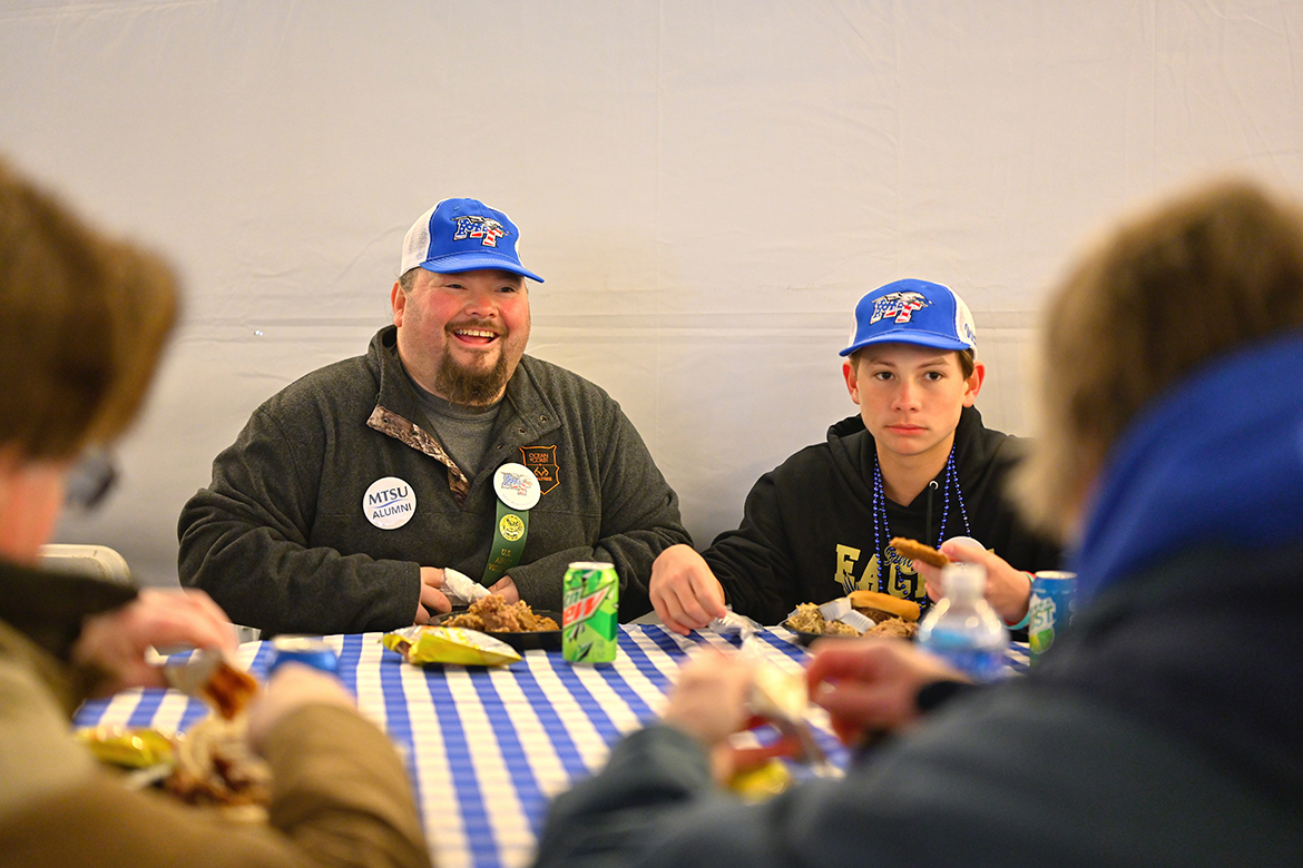 A father and son enjoy both the meal and fellowship during the tailgate picnic as part of the 40th annual Salute to Veterans and Armed Forces game Saturday, Nov. 12, on the MTSU campus. The event was hosted by MT Athletics and the Charlie and Hazel Daniels Veterans and Military Family Center. The MT Blue Raiders defeated the visiting Charlotte 49ers 24-14 in the Conference USA game. (MTSU photo by Cat Curtis Murphy)