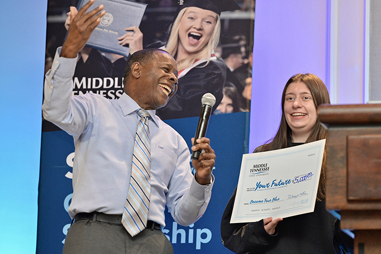 Middle Tennessee State University President Sidney A. McPhee, left, awards a prospective MTSU student a scholarship at the university’s True Blue Tour event at the Cool Springs Marriott in Franklin, Tenn., on Monday, Nov. 14, 2022. (MTSU photo by Andy Heidt)
